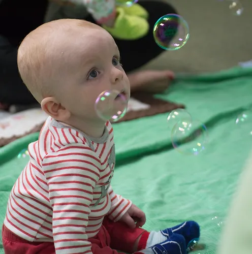 Baby watching soap bubbles in baby music class
