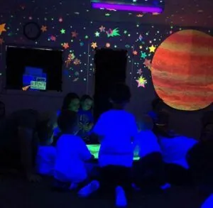 Kids dancing in glow in the dark outer space music class