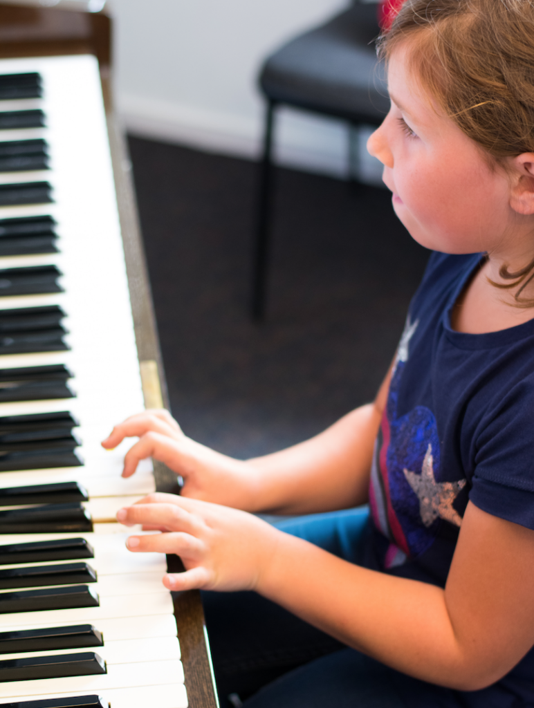 Young girl playing an acoustic piano. 